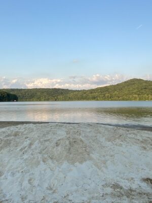About Us - Quemahoning Dam Swimming Area with mountain background